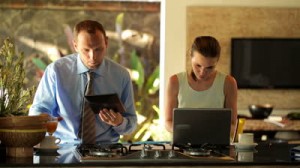 stock-footage-business-couple-with-tablet-computer-and-laptop-in-kitchen-at-home