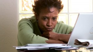 stock-footage-portrait-of-concerned-woman-with-laptop-and-bills (1)